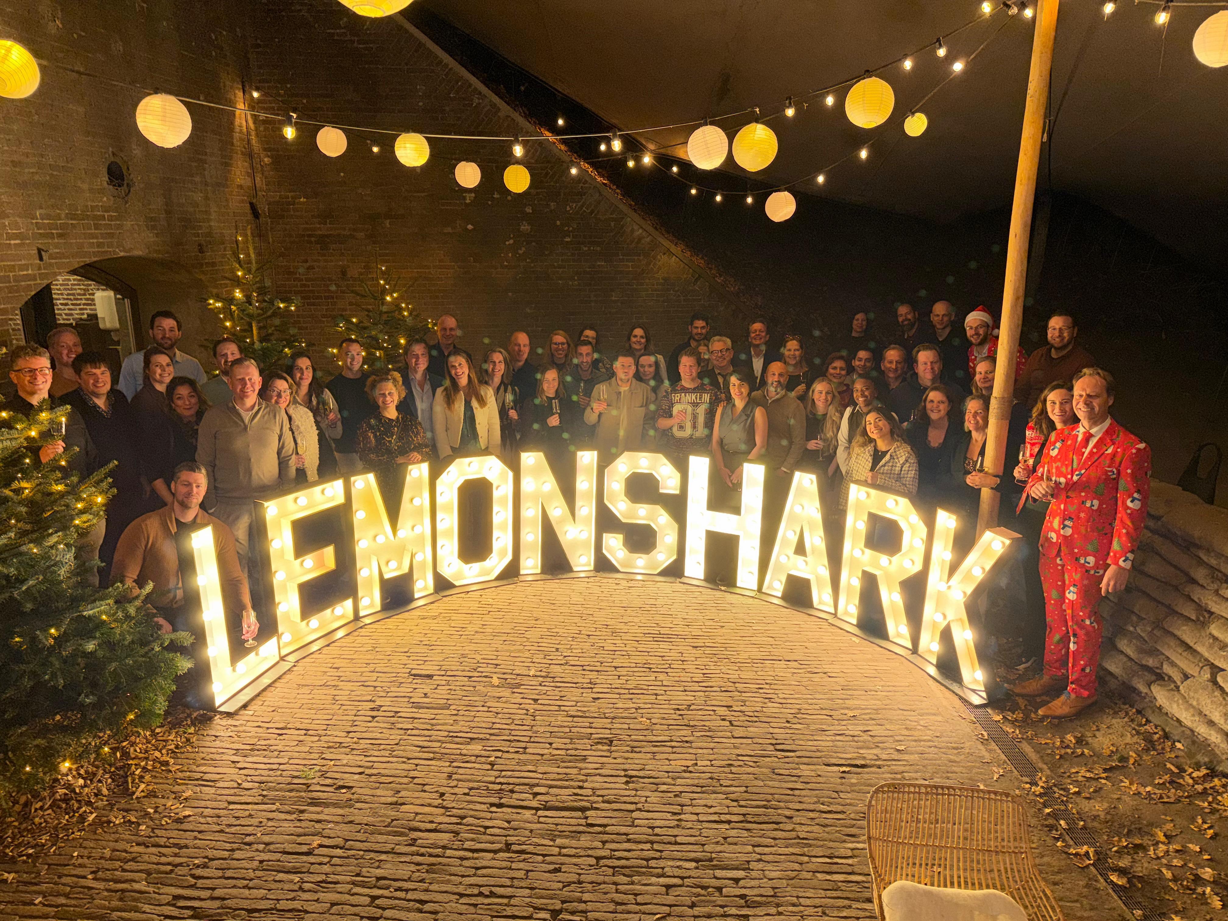Lemoshark Kerstevent 2025 Begin december hadden we weer de laatste Sharkday van het jaar. Dat gaat zoals gebruikelijk gepaard met veel gezelligheid, bijkletsen, taart (ter ere van het behalen van ons NEN4400 certificaat) en kregen we allemaal een prachtig kerstpakket. Zoals altijd had Esther voor een heerlijke lunch gezorgd en bleven een aantal collega's nog voor de spelletjesavond. Maar dat is niet het enige dat we met Kerst doen met de collega’s. Na deze dag konden we al uitkijken naar het einde van de week, het jaarlijkse kerstevent van Lemonshark!